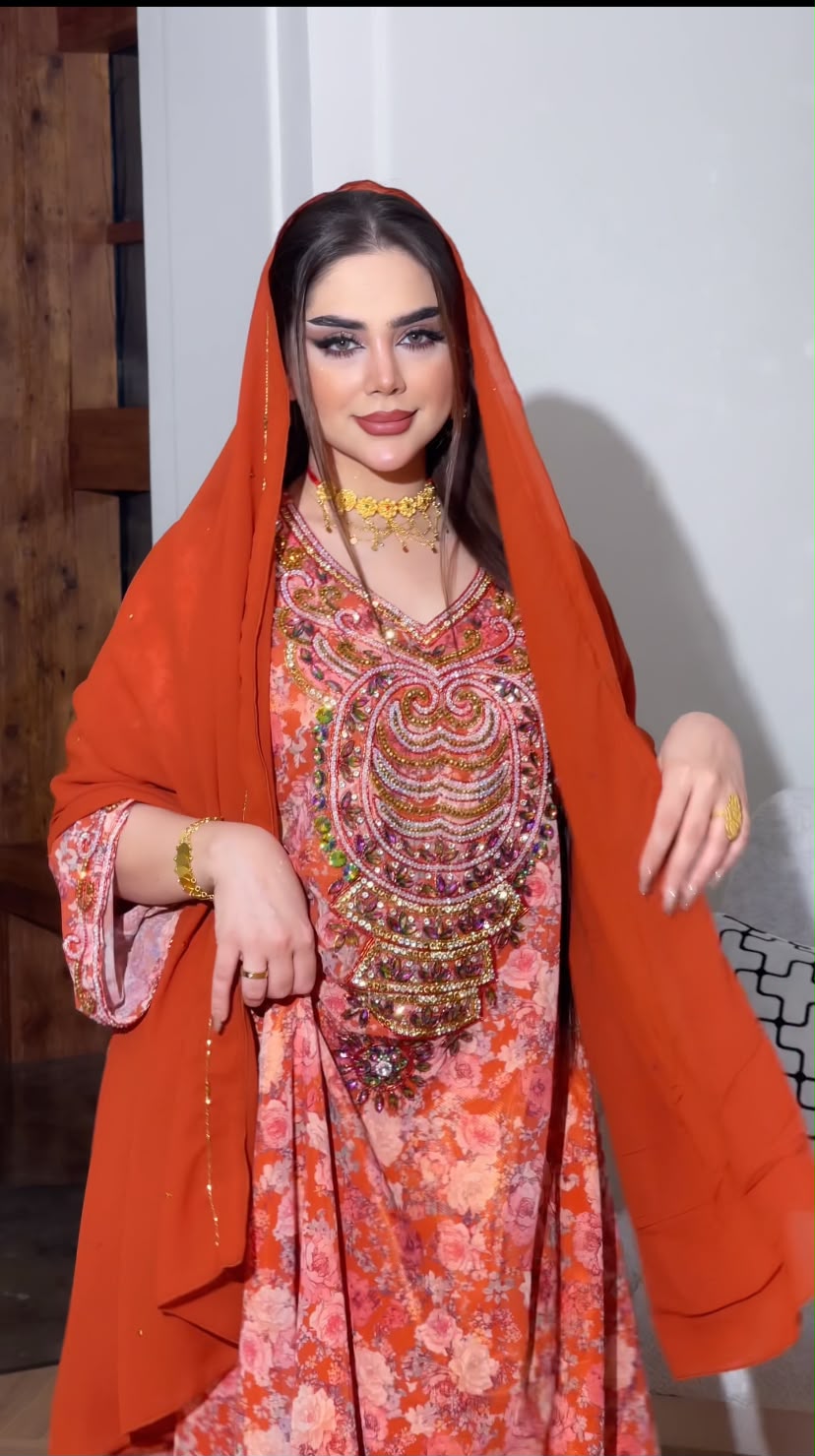 إطلالة تقليدية فاخرة: جلابية مزينة بلمسة عصرية وشيلة برتقالية زاهية
